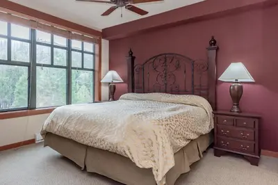 a bedroom with a large bed and two windows at Village 1402 in Mammoth Lakes