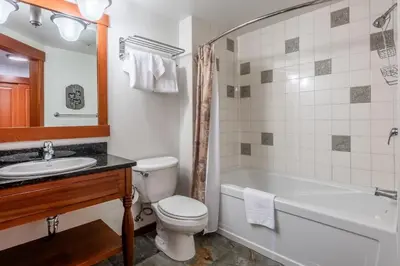 a bathroom with a tub and a toilet and a sink at Village 1402 in Mammoth Lakes