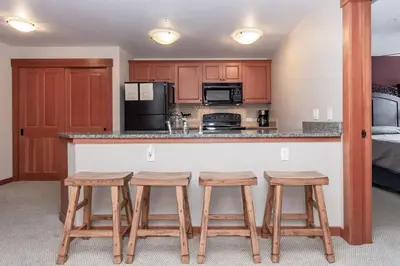 a kitchen with wooden stools and a counter top at Village 1402 in Mammoth Lakes