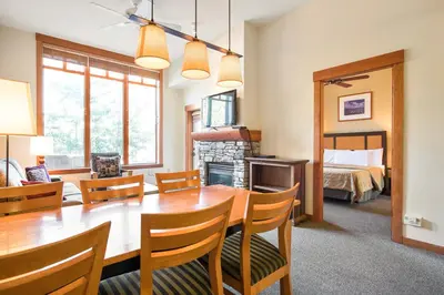 a dining room with a table and chairs and a bedroom at Village 2105 in Mammoth Lakes