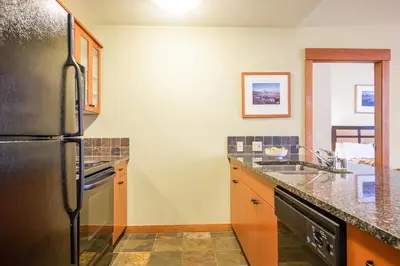 a kitchen with a refrigerator and a sink at Village 2105 in Mammoth Lakes