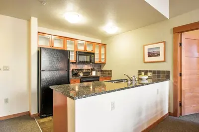 a kitchen with a black refrigerator and a sink at Village 2105 in Mammoth Lakes