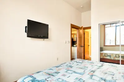 a bedroom with a bed and a tv on the wall at Village 2105 in Mammoth Lakes
