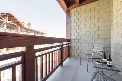 a balcony with a chair and bottles of wine at Village 3311 in Mammoth Lakes