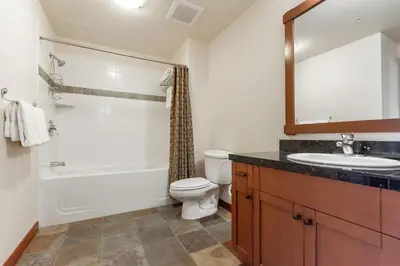 a bathroom with a sink and a toilet and a mirror at Village 3321 in Mammoth Lakes