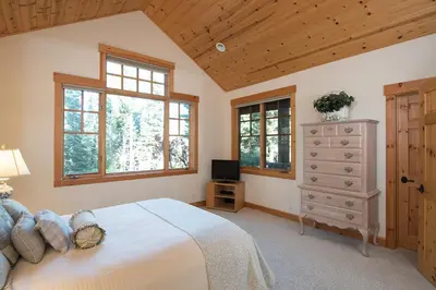 a bedroom with a bed and a dresser and windows at Northstar - Sierra Gold Home in Kingswood Estates