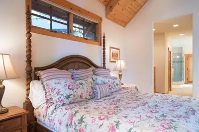 a bedroom with a large bed with a wooden headboard at Northstar - Sierra Gold Home in Kingswood Estates