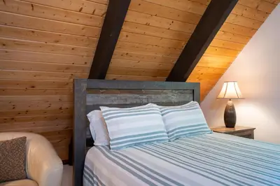 a bedroom with a bed with a wooden ceiling at North Shore - Cozy Cabin in Wood Vista