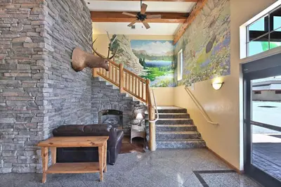 a living room with a staircase and a stone wall at Murphys Suites in Murphys