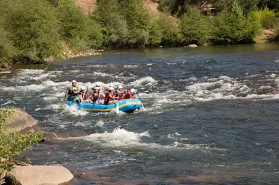 a group of people in a raft on a river at Ponderosa Camping Resort One-Bedroom Cabin 4 in Lotus