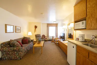 a living room with a couch and a kitchen at Murphys Inn Motel in Murphys