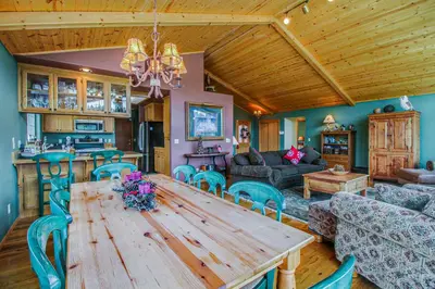 a dining room and living room with a wooden table at Hillside View Home in Truckee