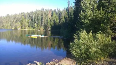 a lake with a boat in the middle of it at Snowflower Camping Resort Cottage 7 in Emigrant Gap