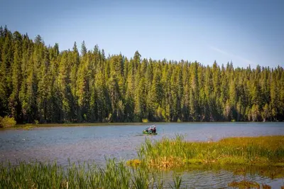 a group of people in a boat on a lake at Snowflower Camping Resort 12 ft. Yurt 9 in Emigrant Gap