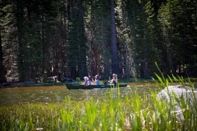 a group of people in a canoe on a river at Snowflower Camping Resort 12 ft. Yurt 9 in Emigrant Gap