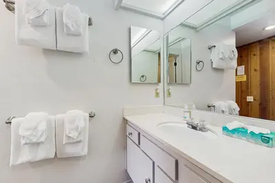 a bathroom with a sink and a mirror and towels at Sunshine Sanctuary in Mammoth Lakes