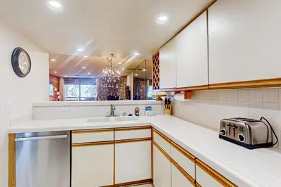 a kitchen with white cabinets and a sink and a toaster at The Bridges 203 in Mammoth Lakes