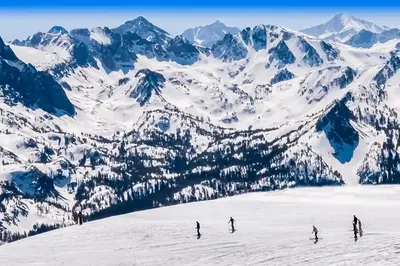 a group of people skiing down a snow covered mountain at The Bridges 203 in Mammoth Lakes