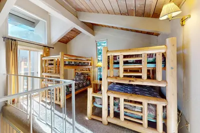 a room with bunk beds and a balcony at Chamonix 100 in Mammoth Lakes