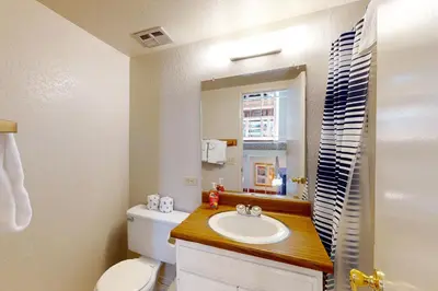 a bathroom with a sink and a toilet and a mirror at Chamonix 100 in Mammoth Lakes