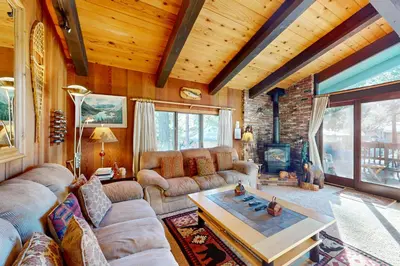 a living room with couches and a table and a fireplace at Chateau Sans Nom 31 in Mammoth Lakes