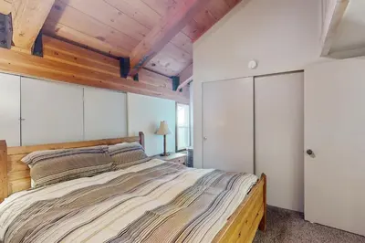 a bedroom with a large bed and wooden ceilings at Courchevel 48 in Mammoth Lakes