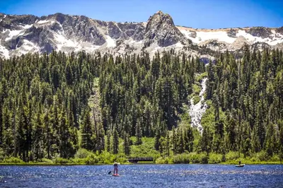 two people in a lake in front of a mountain at Discovery 4 119 in Mammoth Lakes