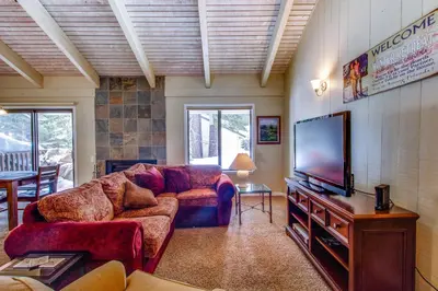a living room with a couch and a flat screen tv at Discovery 4 162 in Mammoth Lakes