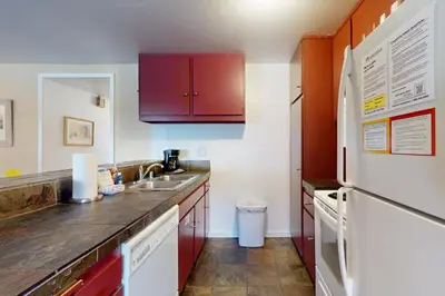 a kitchen with red cabinets and a white refrigerator at Discovery 4 162 in Mammoth Lakes