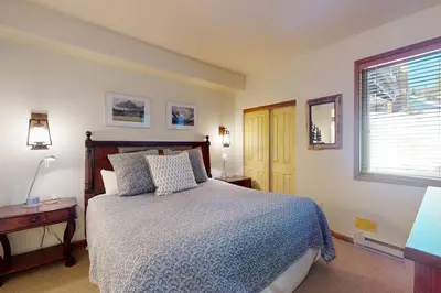 a bedroom with a bed and a table and a window at Eagle Run 107 in Mammoth Lakes