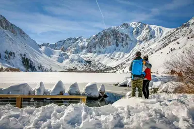 two people flying a kite over a snow covered mountain at Eagle Run 113 in Mammoth Lakes