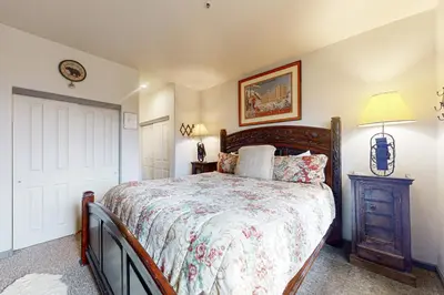 a bedroom with a bed and a lamp and a door at Eagle Run 206 in Mammoth Lakes