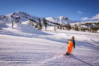 a man is skiing down a snow covered slope at Forest Creek 22 in Mammoth Lakes