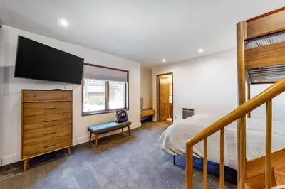 a bedroom with a bed and a dresser with a flat screen tv at Helios North in Mammoth Lakes