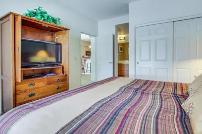 a bedroom with a large bed with a tv on it at Mammoth Green 101 in Mammoth Lakes