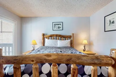a bedroom with a wooden bed with two lamps at Mammoth View Villas 30 in Mammoth Lakes