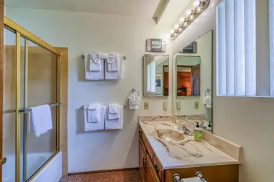 a bathroom with a sink and a shower and a mirror at Snowflower 54 in Mammoth Lakes