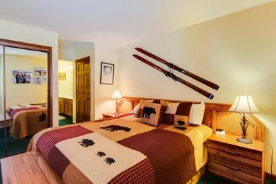 a bedroom with a large bed with a cross on the wall at Sierra Megeve 9 in Mammoth Lakes