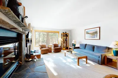 a living room with a blue couch and a fireplace at The Summit 67 in Old Mammoth