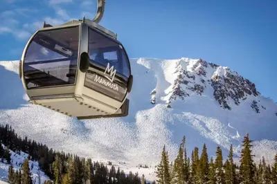 a gondola is flying over a snow covered mountain at Snowcreek 233 in Mammoth Lakes