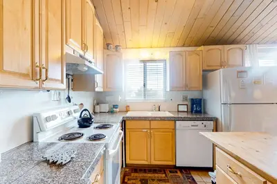 a kitchen with white appliances and wooden cabinets at Timberline 35 in Mammoth Lakes
