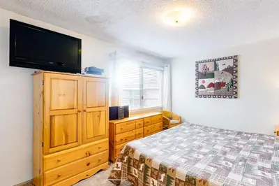 a bedroom with a bed and a flat screen tv at Timberline 35 in Mammoth Lakes
