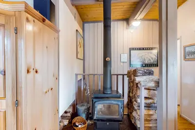 a wood stove in a room with a pile of logs at Timberline 35 in Mammoth Lakes