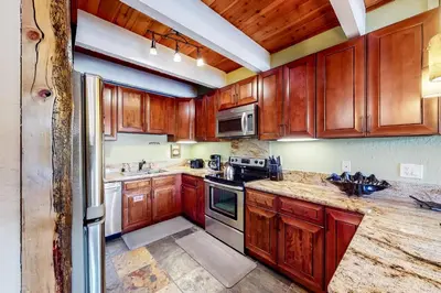 a kitchen with wooden cabinets and stainless steel appliances at Val D'Isere 26 in Mammoth Lakes