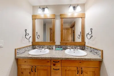 a bathroom with two sinks and two mirrors at Lodestar Cabins in Mammoth Lakes