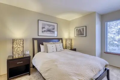 a bedroom with a bed and two lamps and a window at Snowcreek 590 in Mammoth Lakes