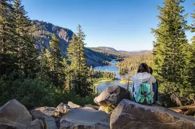 a woman sitting on a rock overlooking a lake at Snowcreek 590 in Mammoth Lakes