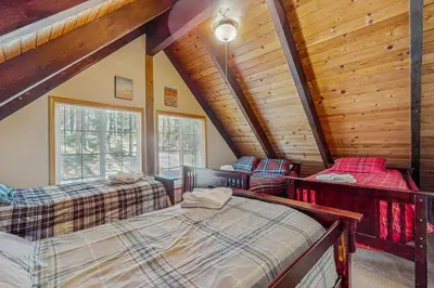 three beds in a room with wooden ceilings at Charming Tahoe Chalet in Tahoe Valley