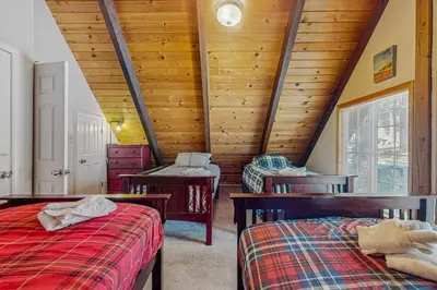 a attic bedroom with two beds and wooden ceilings at Charming Tahoe Chalet in Tahoe Valley