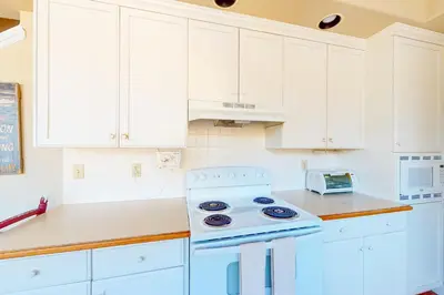 a kitchen with white cabinets and a white stove top oven at Great Escape Cabin (08/253) in Groveland